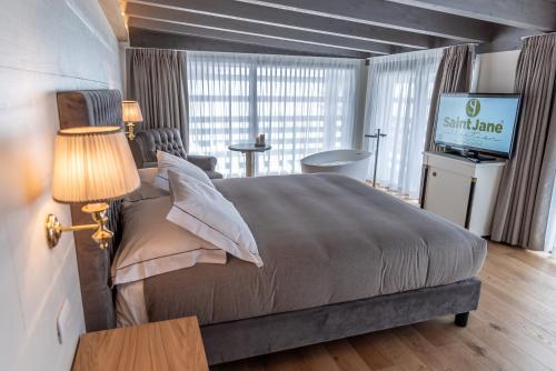 a bedroom with a large bed with a television in it at Cristallo Wellness Hotel in Aprica