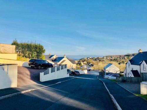 a street with a car parked in a residential neighborhood at Ruby Willow’s in Saundersfoot