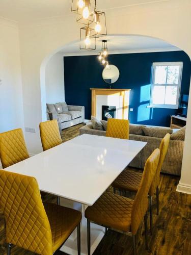 a dining room with a white table and chairs at Ruby Willow’s in Saundersfoot