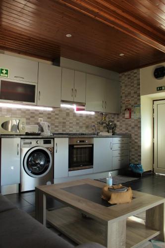 a kitchen with white cabinets and a table in it at Casa do Avô in Vasco Esteves de Baixo