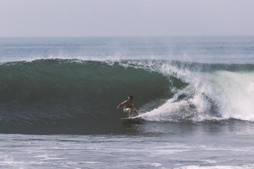 a man riding a wave on a surfboard in the ocean at Suites de Mita - Boutique Hotel in Punta Mita