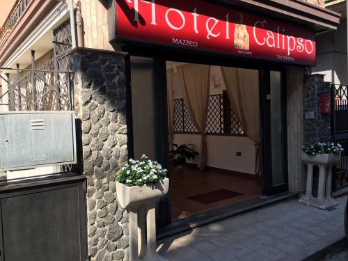 a store front with a window with a flower pot at Taormina Hotel Calipso in Mazzeo