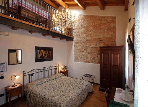 a bedroom with a bed and a chandelier at Fattoria Grimana in Montegalda