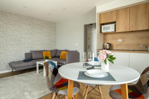 a kitchen and living room with a white table and chairs at "The House" Апартаменти и Термална зона in Velingrad