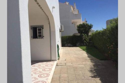 a hallway leading to a white building with an archway at Moradia em Altura! Beach House in Altura