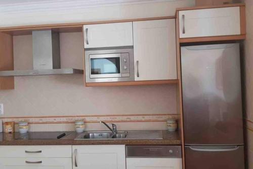 a small kitchen with a sink and a microwave at Moradia em Altura! Beach House in Altura