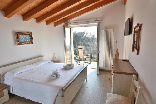 Blue Apartment in Marciaga di Costermano في كوسترمانو: غرفة نوم بسرير ونافذة كبيرة