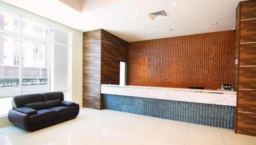 soggiorno con poltrona in pelle e bar di Putatan Platinum Hotel a Kota Kinabalu