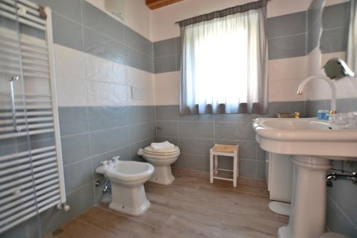 łazienka z umywalką, toaletą i oknem w obiekcie Red Apartment in Marciaga di Costermano w mieście Costermano