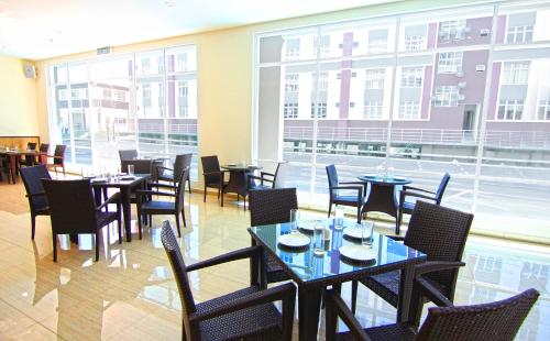 a restaurant with tables and chairs and a large window at Putatan Platinum Hotel in Kota Kinabalu