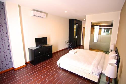 a bedroom with a white bed and a television at Putatan Platinum Hotel in Kota Kinabalu