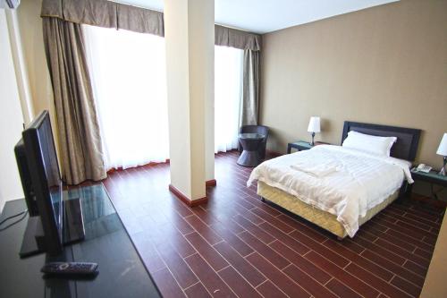 a bedroom with a bed and a flat screen tv at Putatan Platinum Hotel in Kota Kinabalu