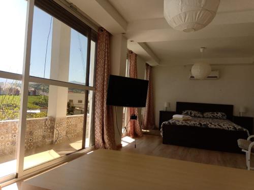 a bedroom with a bed and a large window at Taza Organic Garden with view park and restaurant in Taza