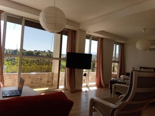 a living room with a couch and a tv and windows at Taza Organic Garden with view park and restaurant in Taza