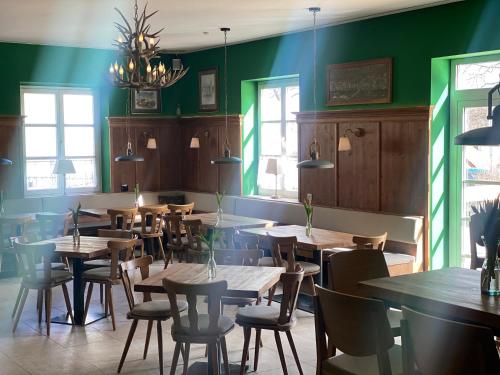 un restaurante con mesas, sillas y paredes verdes en Hotel Waitzingers, en Landsberg am Lech
