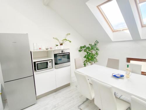 una cucina bianca con tavolo bianco ed elettrodomestici bianchi di Loft with Rooftop and Garage a Budapest