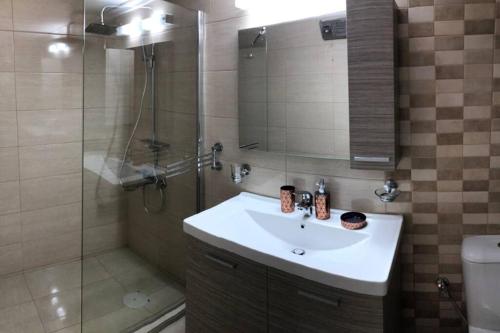 a bathroom with a sink and a shower at Loutraki Vibes Apartments in Loutraki