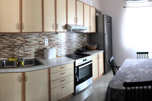 a kitchen with a sink and a stove top oven at Loutraki Vibes Apartments in Loutraki