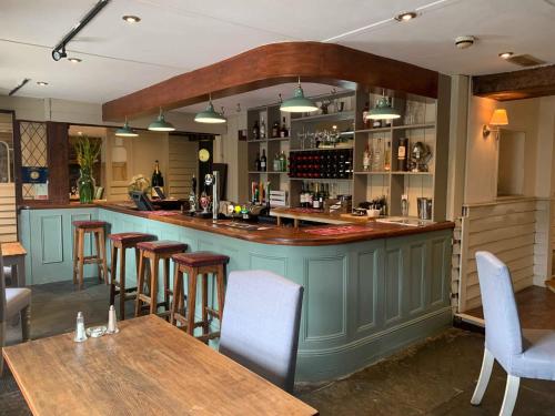 a bar in a restaurant with wooden tables and chairs at The Dartmoor Inn at Lydford in Lydford