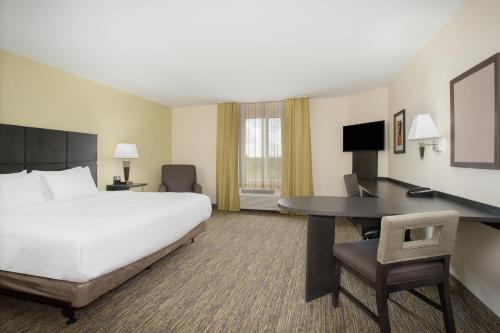 a hotel room with a large bed and a desk at Candlewood Suites Dickinson, an IHG Hotel in Dickinson