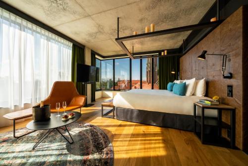 a hotel room with a bed and a large window at The Bridge Wroclaw - MGallery in Wrocław