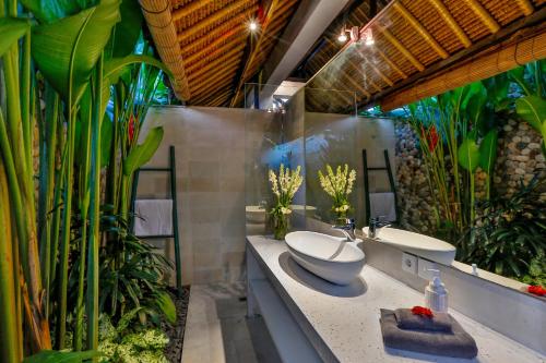 a bathroom with two sinks and some plants at Villa Elleo in Seminyak