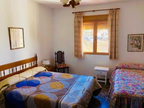 - une chambre avec 2 lits et une fenêtre dans l'établissement Chalet Embalse Bermejales, à Arenas del Rey