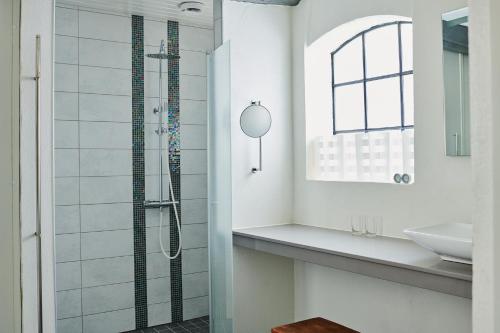 a bathroom with a shower and a sink at Gladsax Gårdshotell in Simrishamn