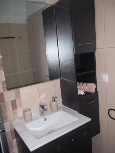 a bathroom with a white sink and a mirror at Romantic House Sea View Adults only in Ios Chora