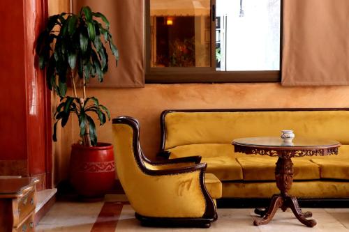 a living room with a couch and a table and a chair at Hôtel Rembrandt in Tangier