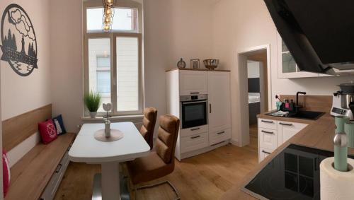 a kitchen with a table and a table and chairs at MEERzeit-Norderney in Norderney