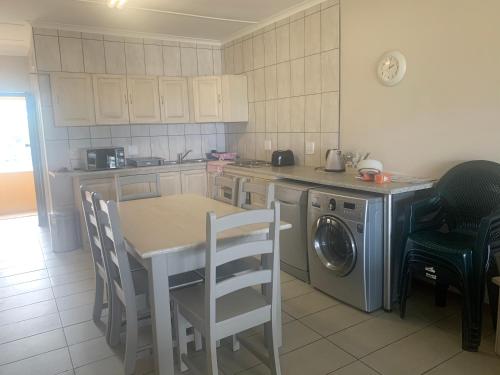 a kitchen with a table and a washing machine at Holiday unit 37 Eden dunes in Shelly Beach