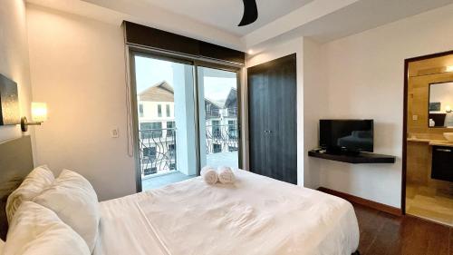 a bedroom with a white bed and a large window at Luxury SKY PENTHOUSES 3-6BR Condo-Hotel at Oceano Jaco in Jacó