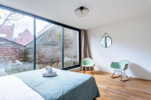 um quarto com uma cama e uma grande janela em NOCNOC - Le Ténor, Monnaie em Lille