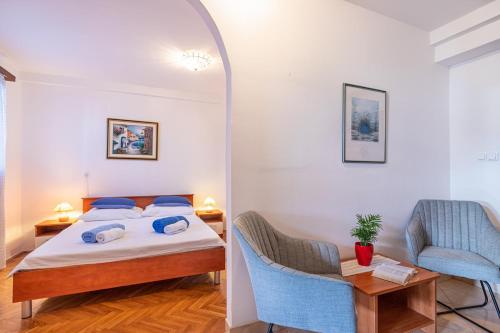 1 dormitorio con 1 cama, mesa y sillas en Apartments Alida, en Poreč