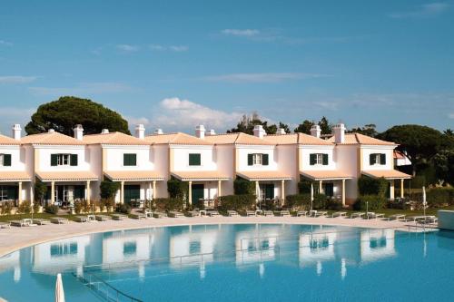 a resort with a large swimming pool and chairs at Vila Bicuda Resort in Cascais