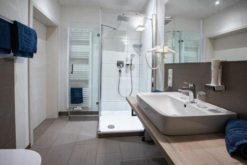 a bathroom with a shower and a sink and a tub at CAESARO Hotel & Pizzeria - 20 Jahre Familienunternehmen in Hagen