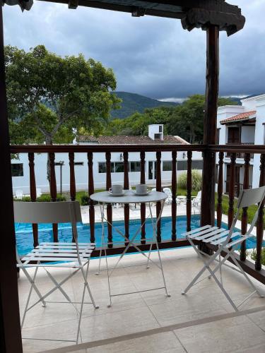 a table and chairs on a balcony with a pool at Posada de los Poetas Hotel Boutique in San Lorenzo