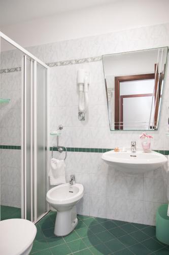 a bathroom with a sink and a toilet and a mirror at Viva Beach Hotel - 20m from the Beach & Large Breakfast in Rimini