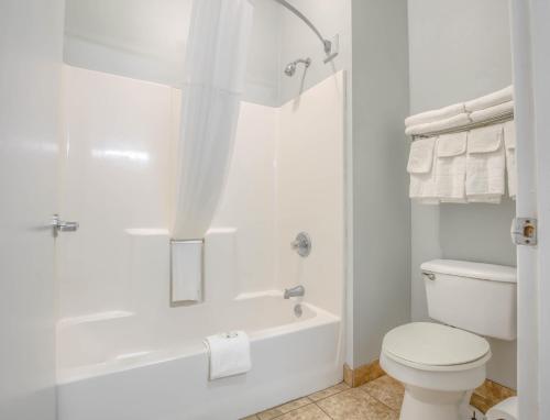 a white bathroom with a tub and a toilet at Quality Inn in Gulf Shores