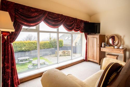 uma sala de estar com uma grande janela em The Village Inn em Longframlington