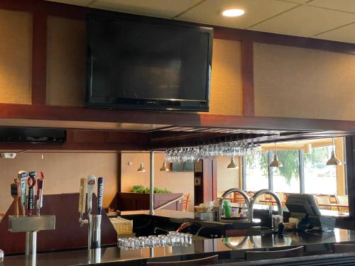 a kitchen with a bar with a television on the wall at Holiday Inn Bangor by IHG in Bangor