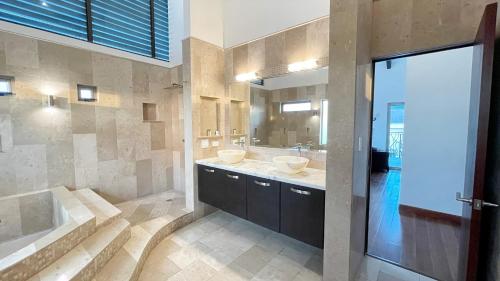a bathroom with two sinks and a tub and a shower at Luxury SKY PENTHOUSES 3-6BR Condo-Hotel at Oceano Jaco in Jacó