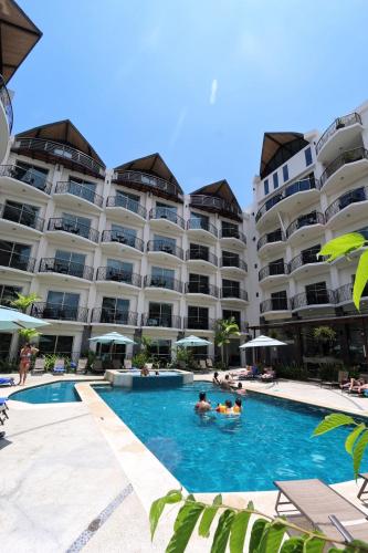 a hotel with a swimming pool in front of a building at Luxury SKY PENTHOUSES 3-6BR Condo-Hotel at Oceano Jaco in Jacó