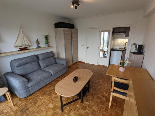 a living room with a couch and a table at STUDIO MET FRONTAAL ZEEZICHT in Middelkerke