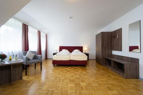 a bedroom with a bed and a desk and a chair at Hotel Grosse Klus in Bückeburg