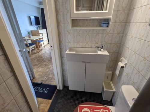 a small bathroom with a sink and a table at STUDIO MET FRONTAAL ZEEZICHT in Middelkerke