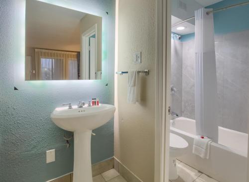 y baño con lavabo, aseo y ducha. en Days Inn by Wyndham Mobile I-65, en Mobile