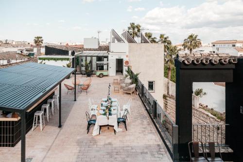 a patio with tables and chairs on a roof at ASTUTO Boutique Jerez - Adults Only in Jerez de la Frontera