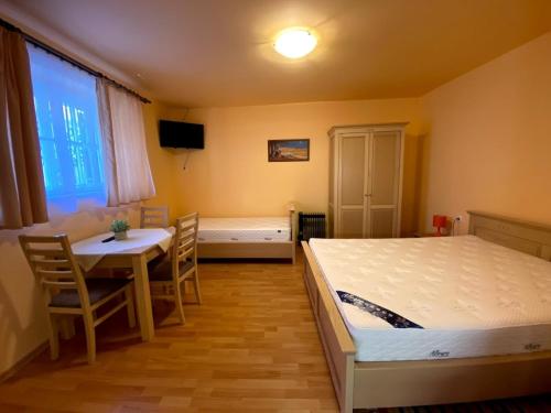 a bedroom with a bed and a table and a table and chairs at Fehérház Alkalmi Szálló in Pécs